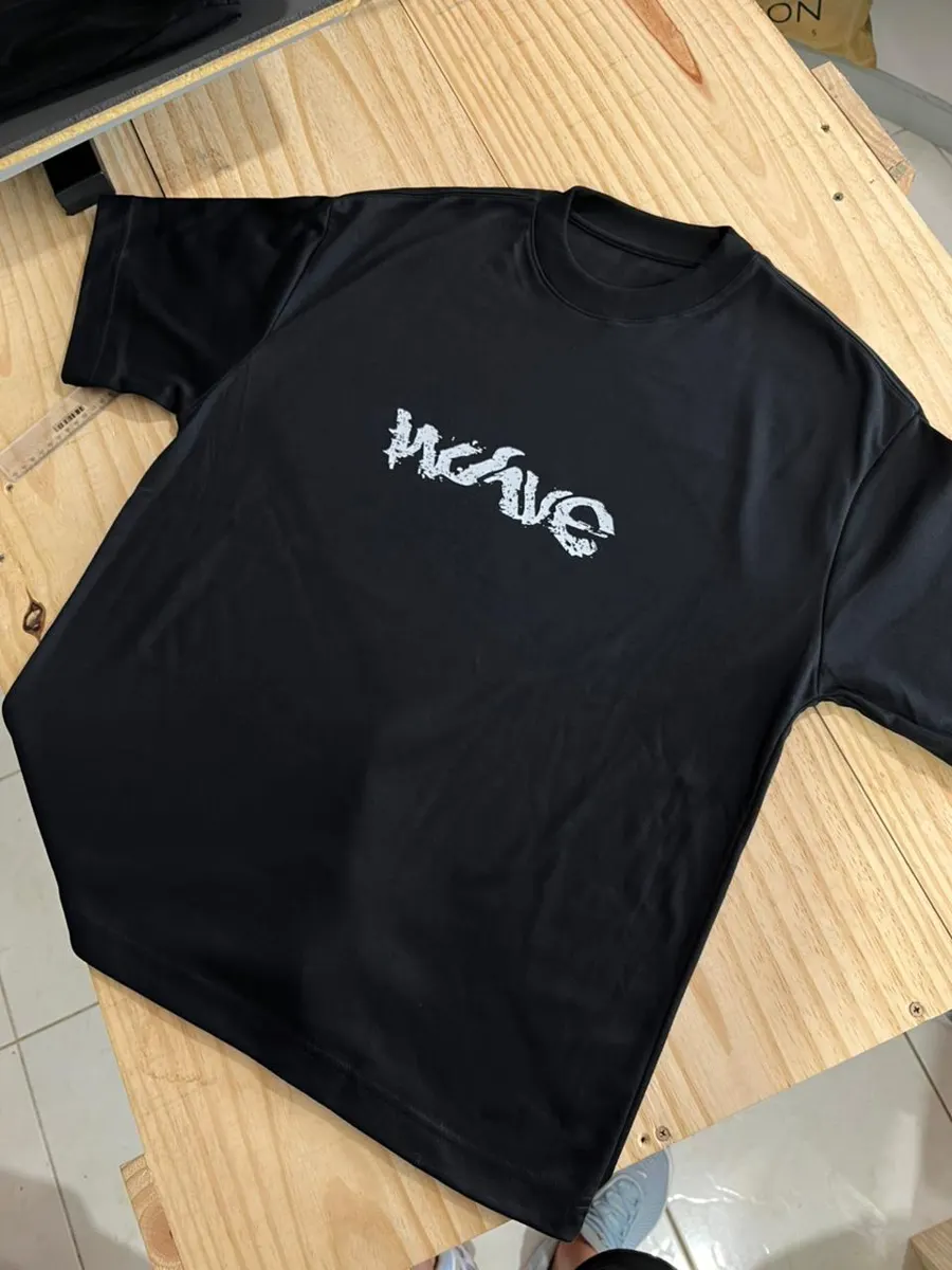 Camiseta oversized preta com a palavra Wave estampada em branco no peito